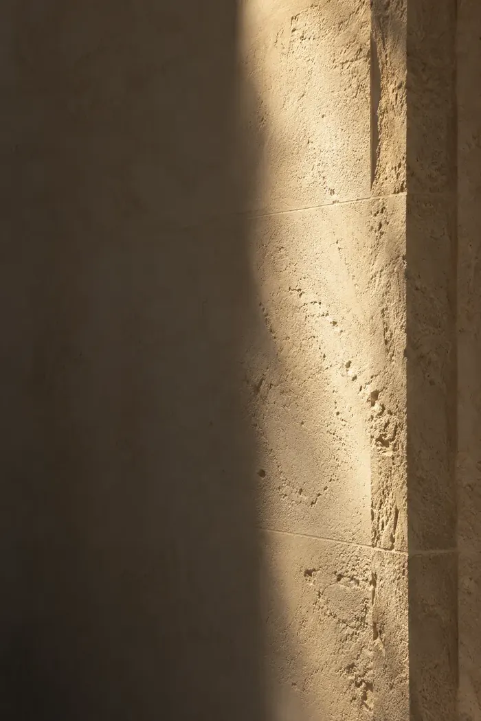 Luce che scende su una parete in pietra
